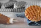 un muffin à la crème de marrons et une poche à douille remplie de crème de marrons, en couleur sur un fond noir et blanc