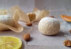au centre, un amaretti citron, entourés de plusieurs amarettis citron, d'amandes et de tranches de citron