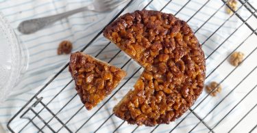 Gâteau aux noix caramélisées recouvert d'une couche généreuse de noix