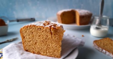 part de gâteau au yaourt, recette de julie andrieu, avec le gâteau et un yaourt dans le fond