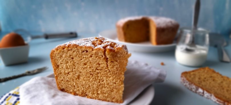 part de gâteau au yaourt, recette de julie andrieu, avec le gâteau et un yaourt dans le fond